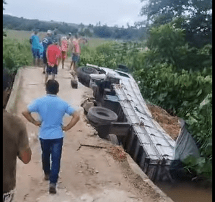 Caminhão tomba e cai em ribanceira após passagem molhada ceder, em Mataraca